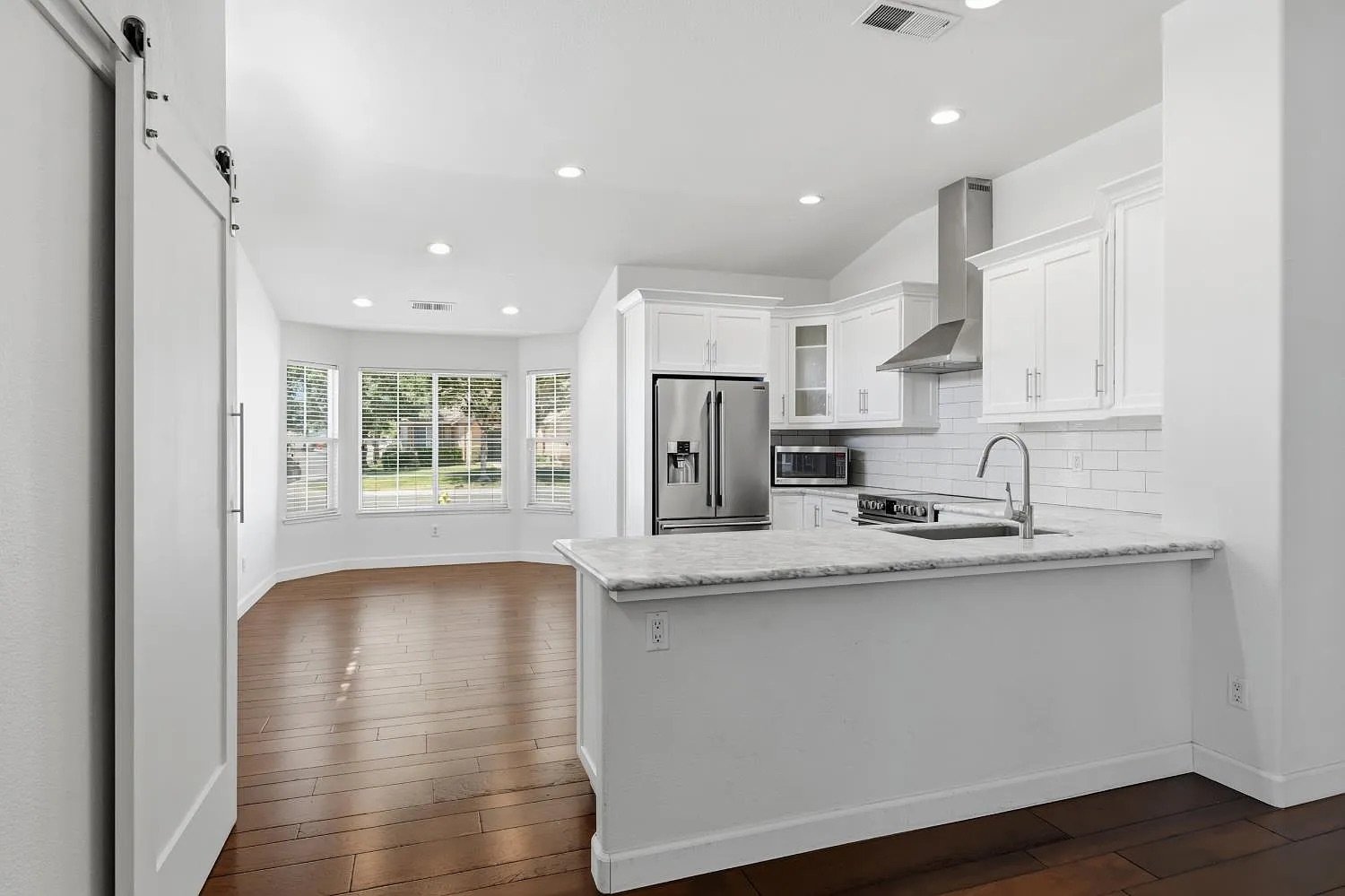 Kitchen Peninsula with Marble Counters and Stainless Appliances
