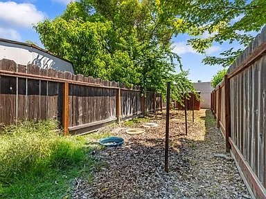 Side Yard — mature trees, mulch, fenced