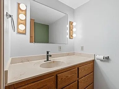 Bathroom — quartz-look vanity, Hollywood lighting